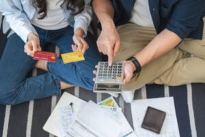 Couple sitting hand calculating expenses representing bankruptcy debts.